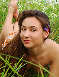 Bysya is in the middle of a field picking flowers nude.